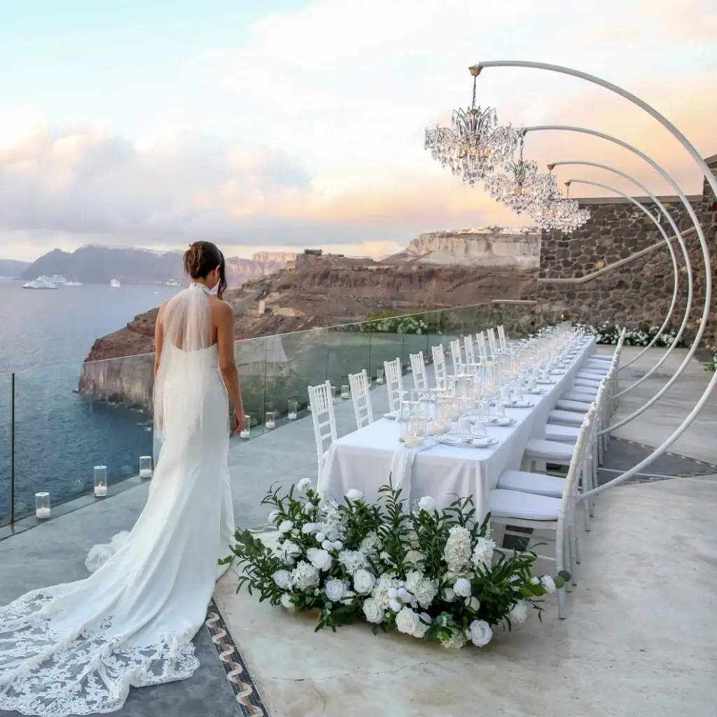 Elegant wedding reception dinner table lighting with hanging crystal chandeliers Santorini