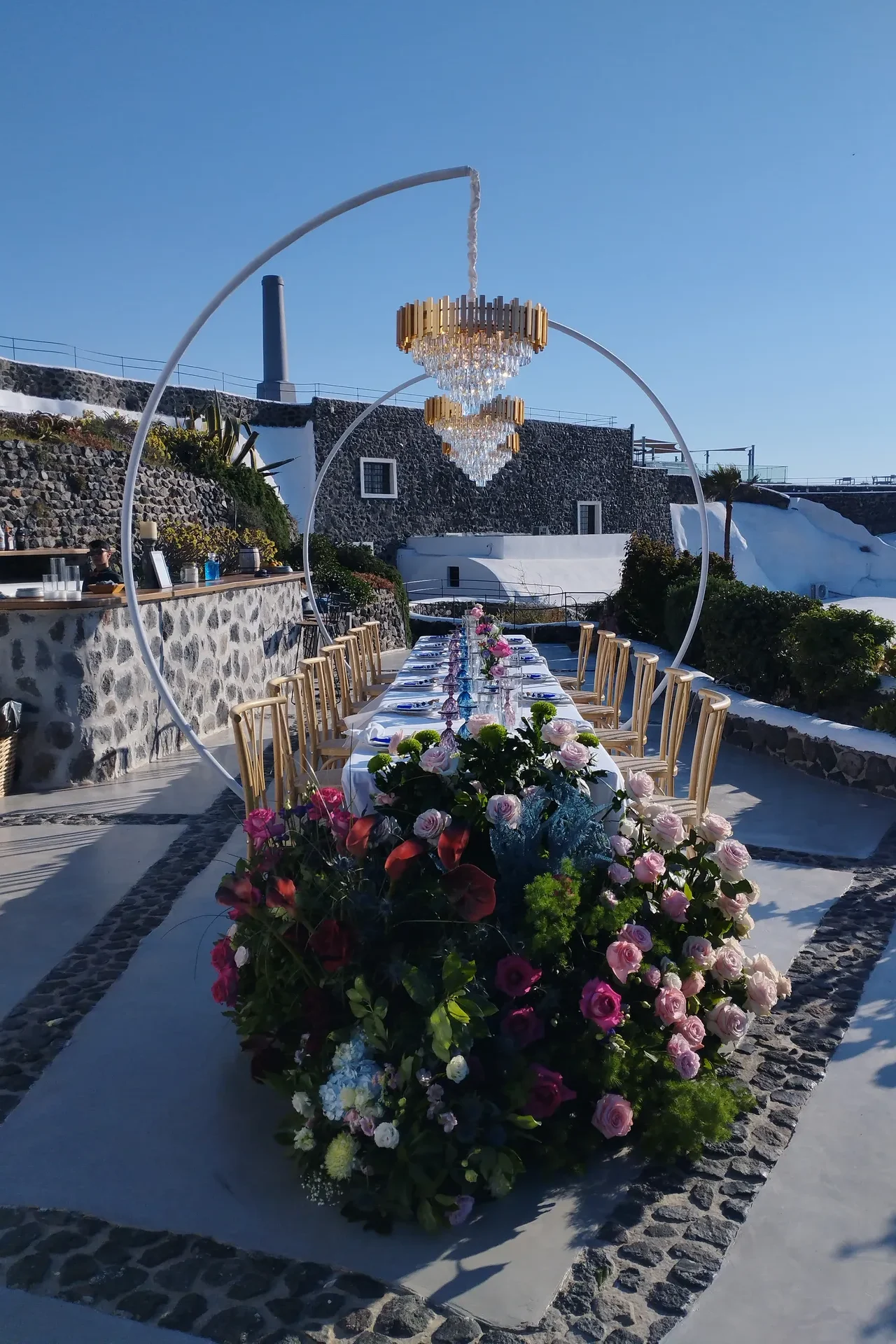 Katarina crystal chandelier above a long outdoor wedding table in Santorini, Greece